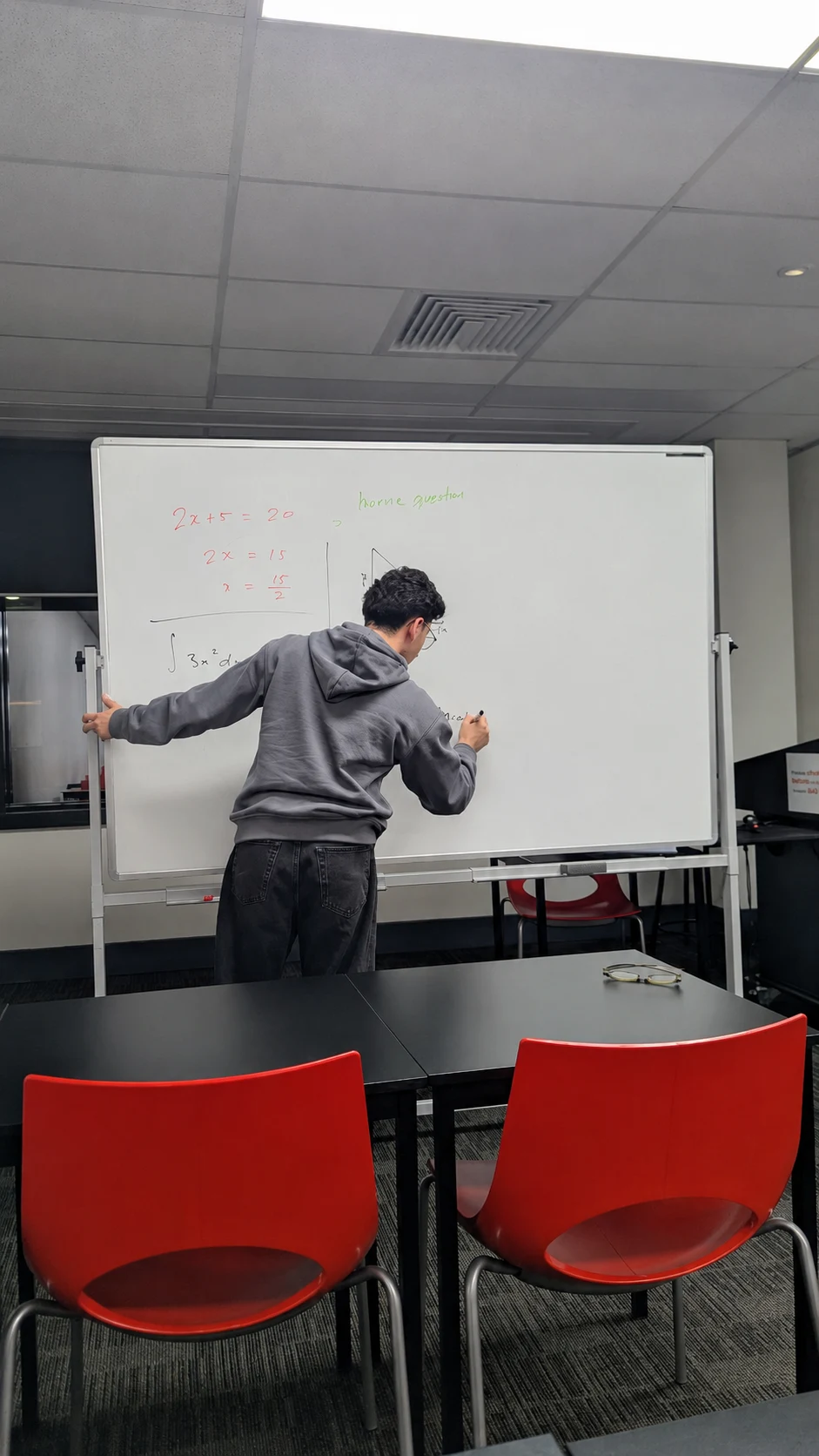 A Vertex tutor working through mathematics at the whiteboard